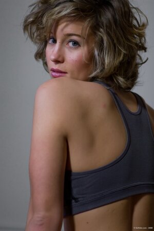 Blonde with big hair shows off her shaved pussy on the floor