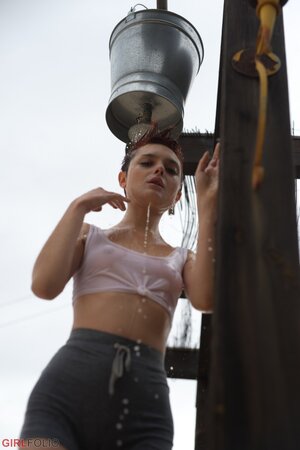 Short red-haired girl with freckles smokes after getting wet