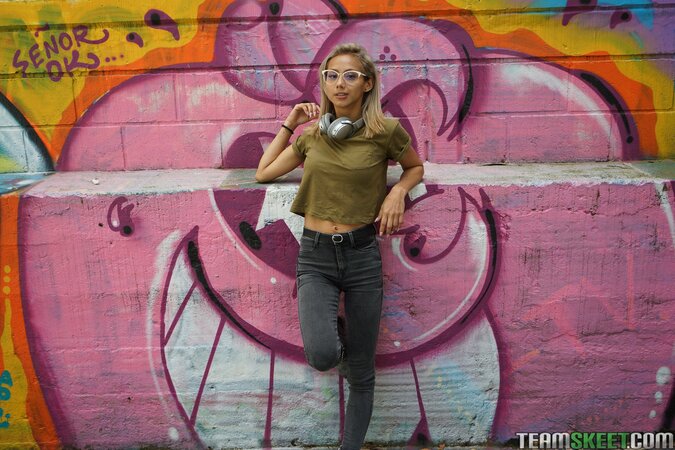 Veronica Leal poses on hood in green shirt and tight jeans