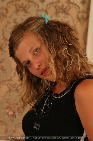 Bimbo chick with nice boobs provocatively undresses being alone in bedroom