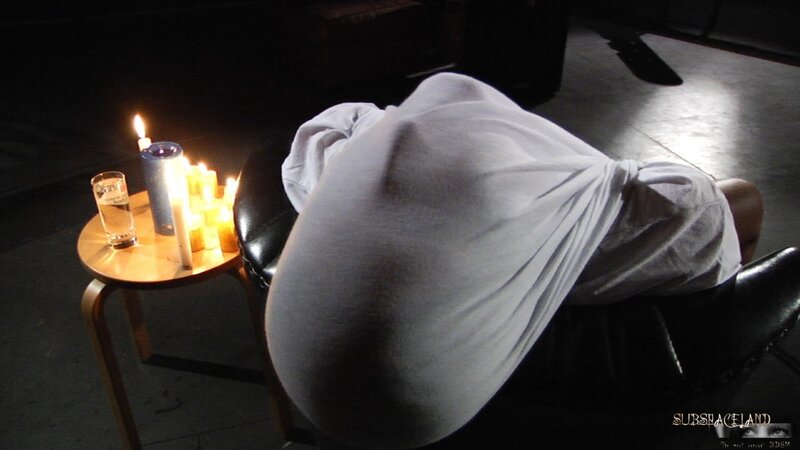 Dominant man lights a candle and pours girl's slender body with hot wax