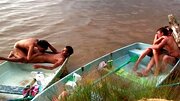 Horny people are having group sex on the beach in a small boat